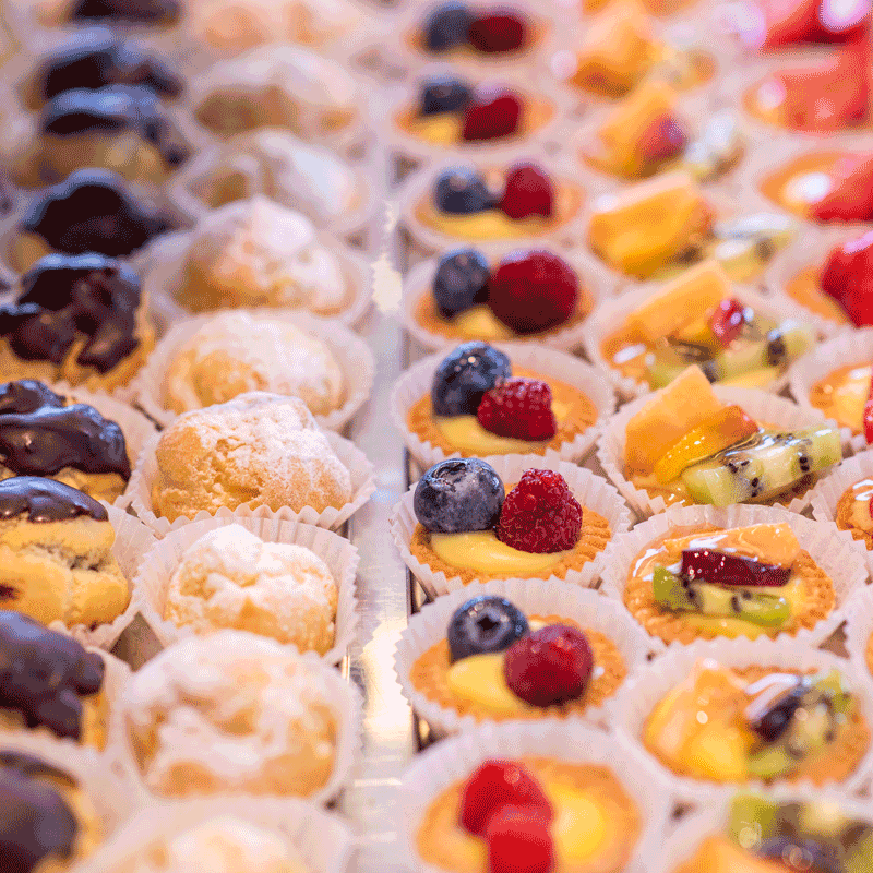 Pausa Pranzo. Che pasticcini! Bignè ripieni al cioccolato e alla crema. Cartellette con crema pasticciera e frutta.