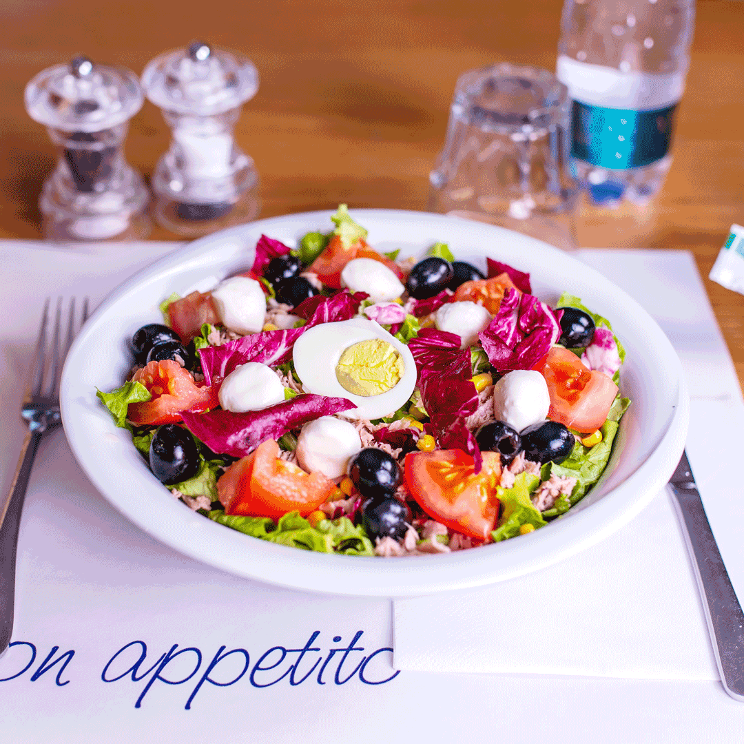 Insalatona bella fresca. Uova, pomodori, foglie di insalata, olive e tonno.
